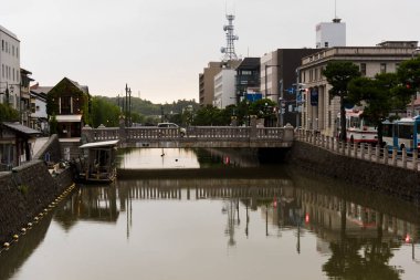 Sakin şehir kanalı bulutlu sabahlarda binaları yansıtıyor