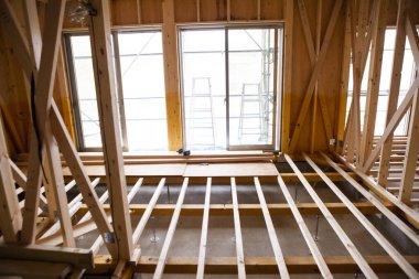 Ahşap bina inşaatında çalışan Asyalı genç bir inşaatçının portresi.