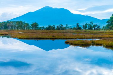Göldeki sisli dağların güzel yansıması