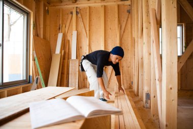 İnşaatta çalışan genç Asyalı marangozun portresi