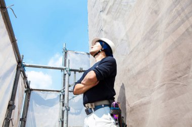 İnşaat alanında poz veren yakışıklı Japon işçinin portresi.