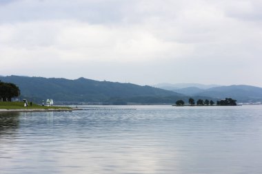 Göl yeşil dağlarda ve bulutlu gökyüzünde 
