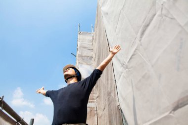 İnşaat alanında poz veren yakışıklı Japon işçinin portresi.