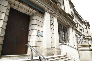 Büyük ahşap kapılar ve kolonların bulunduğu bina girişi.