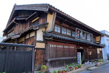 Geleneksel Japon ahşap binasının dışında saksı bitkileri var.