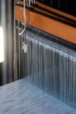 Ahşap dokuma tezgahından sarkan dikey iplikleri göster