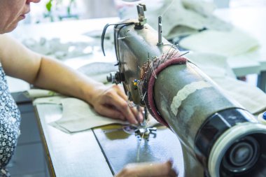 Masada dikiş makinesi kullanan kişi kumaş dikiyor