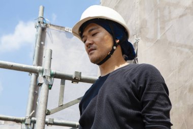 İnşaat alanında poz veren yakışıklı Japon işçinin portresi.