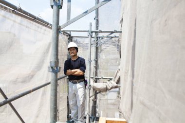 İnşaat alanında poz veren yakışıklı Japon işçinin portresi.