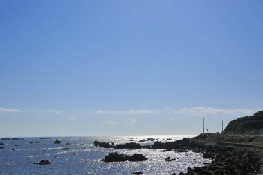 Mavi gökyüzü ve deniz taşlarla