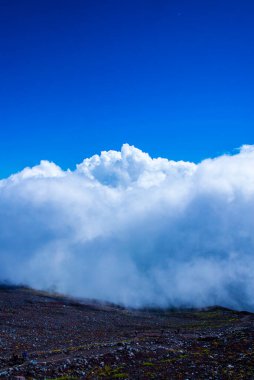 Dağ zirvesi manzarası ve mavi gökyüzündeki bulutlar 