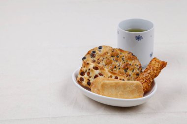 Gri masadaki kurabiyeli bir fincan çay.