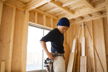 İnşaatta çalışan genç Asyalı marangozun portresi