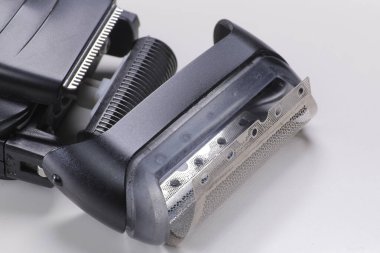 Yakın plan, elektrikli tıraş bıçakları ve plastik kaplama detaylarını gösteriyor.