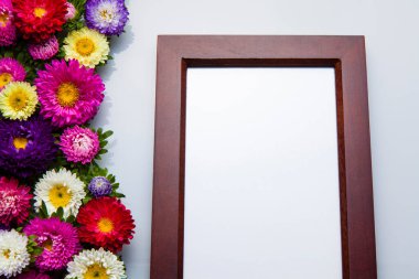 Beyaz arka planda güzel çiçekler olan ahşap fotoğraf çerçevesi.