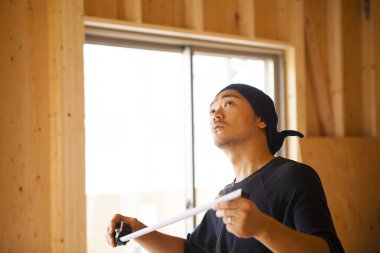 İnşaatta çalışan genç Asyalı marangozun portresi