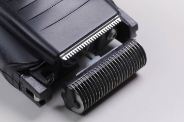 Siyah elektrikli jiletin yakın çekimi bıçaklarını gösteriyor.