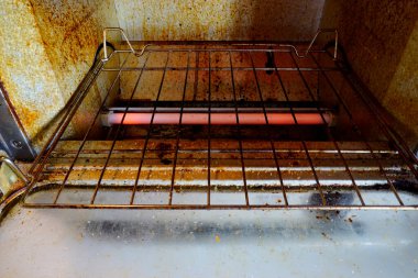 Mutfakta kırmızı lamba olan kirli fırın.