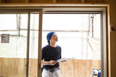 İnşaatta çalışan genç Asyalı marangozun portresi