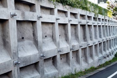 Açılı beton istinat duvarı. Geometrik tekrarlayan desenler açık havada.