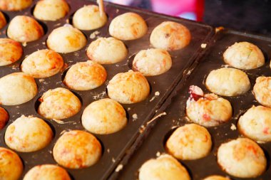 Takoyaki pişirmek, top şeklinde Japon aperatifleri un bazlı hamurdan yapılır ve özel kalıplı bir tavada pişirilir.