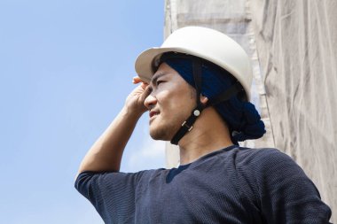 İnşaat alanında poz veren yakışıklı Japon işçinin portresi.