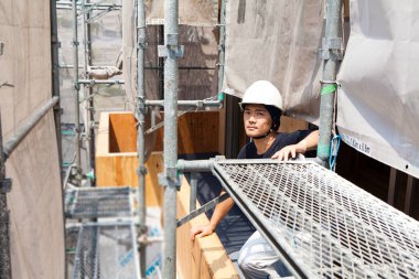 İnşaat alanında poz veren yakışıklı Japon işçinin portresi.