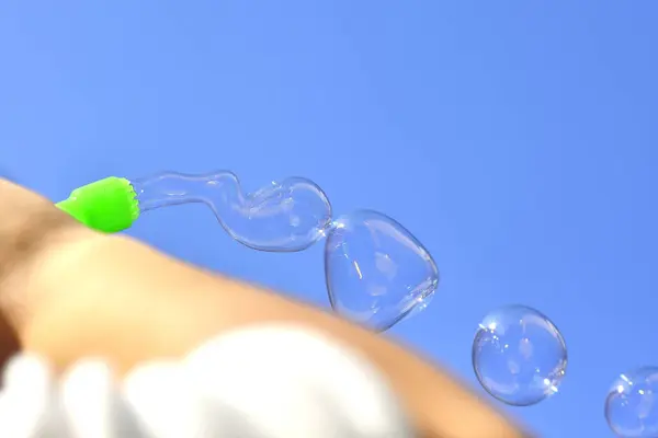 石鹸の泡を吹く子供の手 — ストック写真