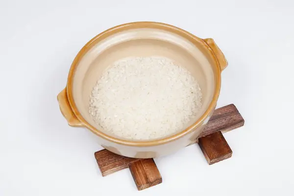 stock image raw rice in bowl on white background. Close up view