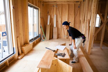 İnşaatta çalışan genç Asyalı marangozun portresi