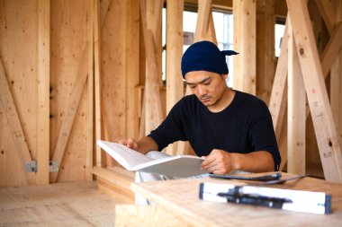 İnşaatta çalışan genç Asyalı marangozun portresi