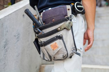 Aletleri olan erkek işçiyi kapat, alet kemeri olan inşaat işçisi. 