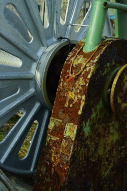 Bir zincir ve boruyla paslı metal tekerlek.