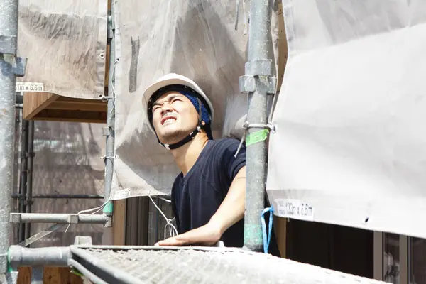 portrait of handsome japanese worker posing on the construction site