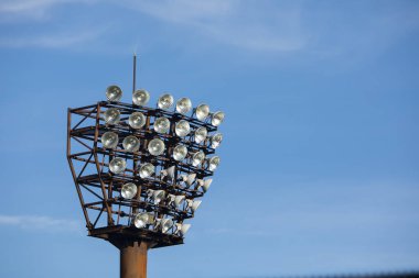 Stadyum ışıkları ve mavi gökyüzü arka planı