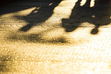 Sabah güneşinde beton zeminde insanların gölgeleri