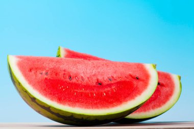 Mavi arka planda taze olgun karpuzun yakın görüntüsü