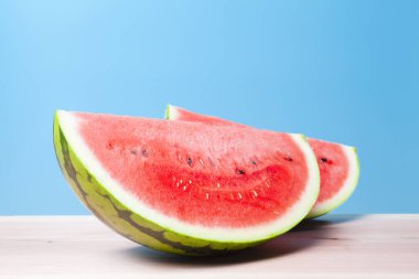 Mavi arka planda taze olgun karpuzun yakın görüntüsü