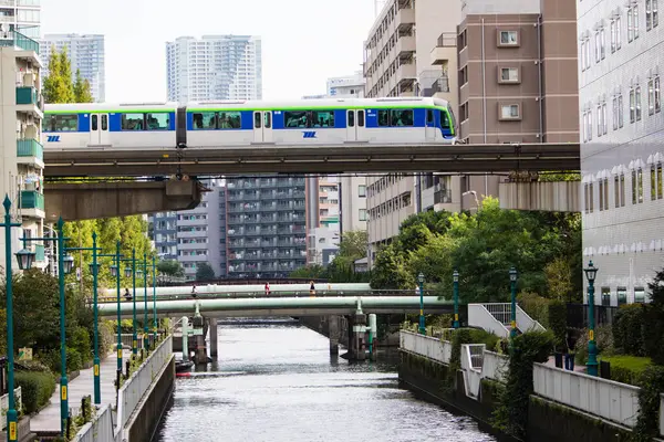 日本の都市を横断する近代的な鉄道で移動する列車 — ストック写真