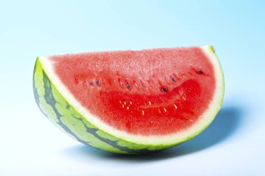 Mavi arka planda taze olgun karpuzun yakın görüntüsü