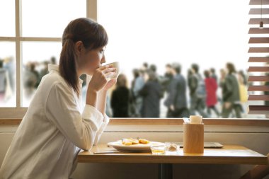 Genç Asyalı kadın kahvaltını kafede yapıyor.