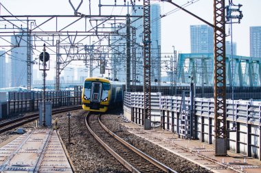 Demiryolu, gün ışığında Japonya 'nın yoğun şehir manzarasını ikiye bölüyor.