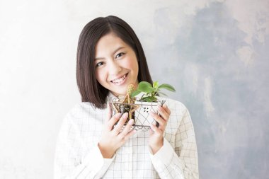 Küçük saksı bitkileri tutan gülümseyen kadın.