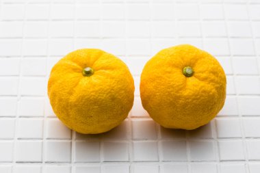 Beyaz fayanslı taze mandalina meyveleri.