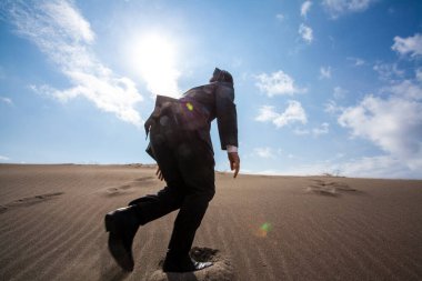Asyalı işadamı kumsalda yürüyor, dikiz manzaralı. 