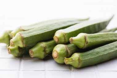 Beyaz karo zemin üzerinde taze bamya