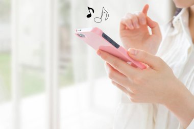 Kadın cep telefonuyla müzik dinliyor, müzik notaları simgeleri