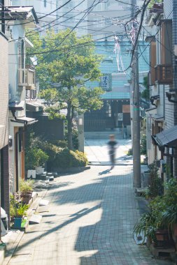 Birkaç bina ve bir ağaç olan dar bir cadde. 