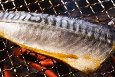 Izgarada balık pişirmek, manzarayı kapatın.