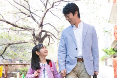 Genç Asyalı baba ve kızı parkta yürüyorlar..